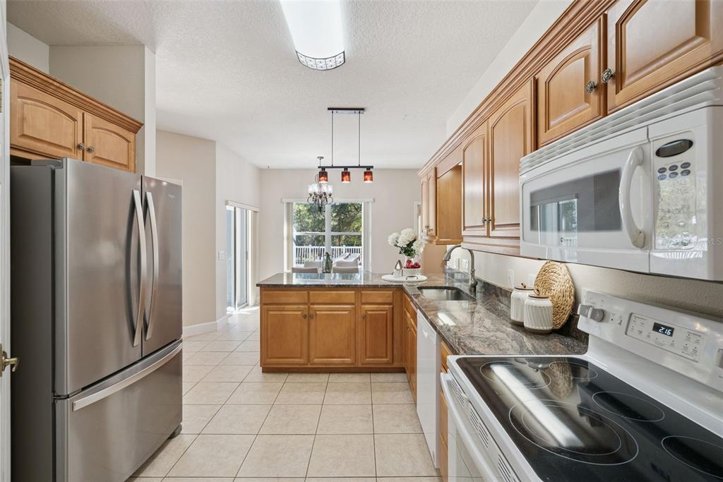 3441 Hickory Creek Road Deltona, FL 32738 - Photo 20 of 62 a kitchen with stainless steel appliances granite countertop a refrigerator a stove and a sink