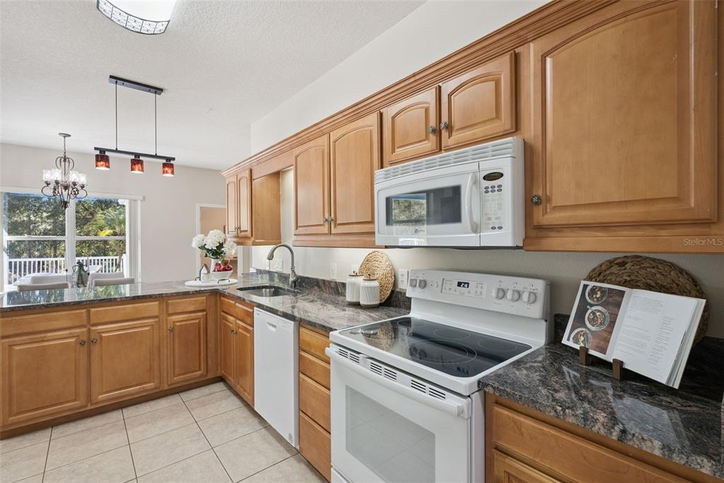 3441 Hickory Creek Road Deltona, FL 32738 - Photo 21 of 62 a kitchen with stainless steel appliances granite countertop a sink stove and cabinets