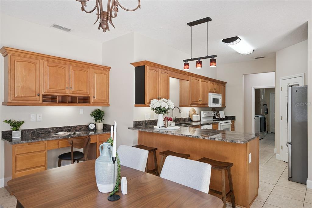 3441 Hickory Creek Road Deltona, FL 32738 - Photo 22 of 62 a kitchen with a refrigerator a sink dishwasher a dining table and chairs with wooden floor