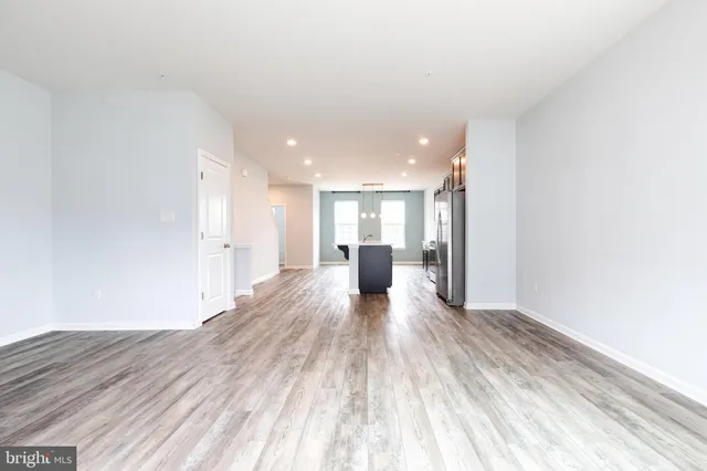 a view of a big room with wooden floor and windows