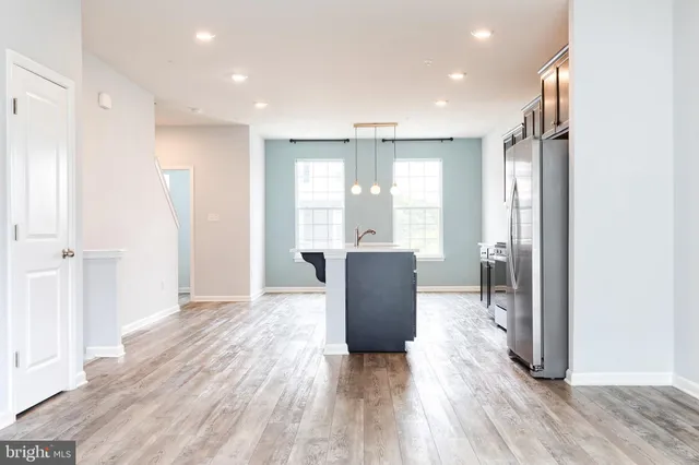a view of kitchen with refrigerator and wooden floor