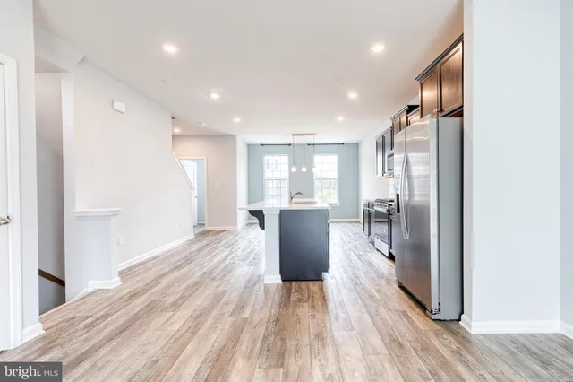a view of a kitchen with wooden floor and a refrigerator