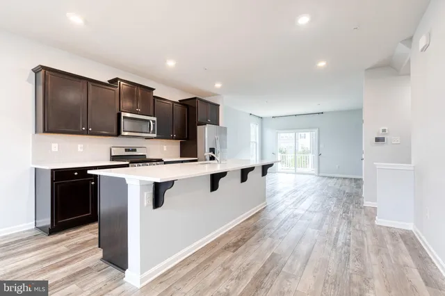 a large kitchen with stainless steel appliances granite countertop a stove a sink and a refrigerator