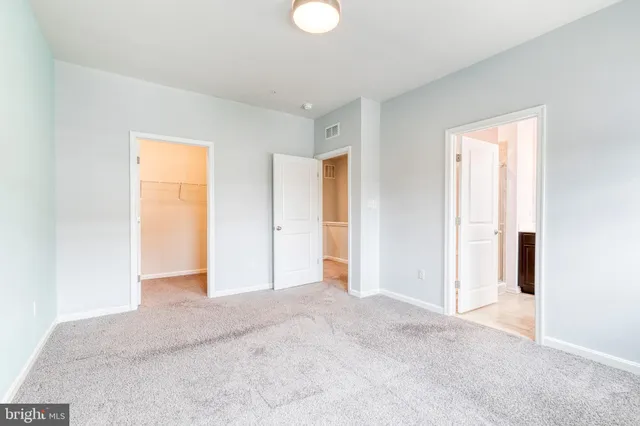 a view of an empty room with window and closet area