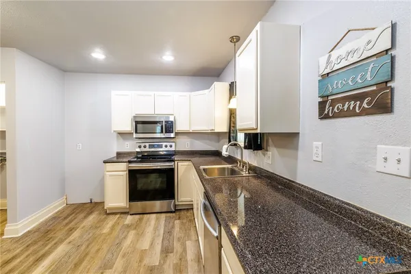 a kitchen with granite countertop a stove and a sink