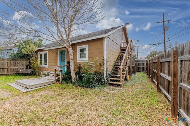 a view of house with backyard and furniture