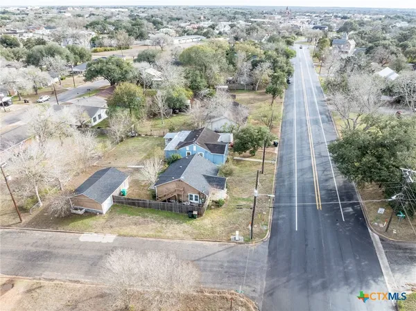 an aerial view of a house with a yard and wooden fence
