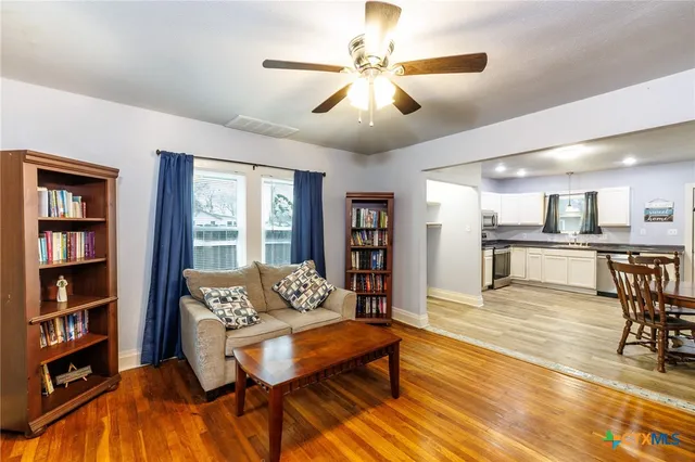 a living room with furniture and a wooden floor