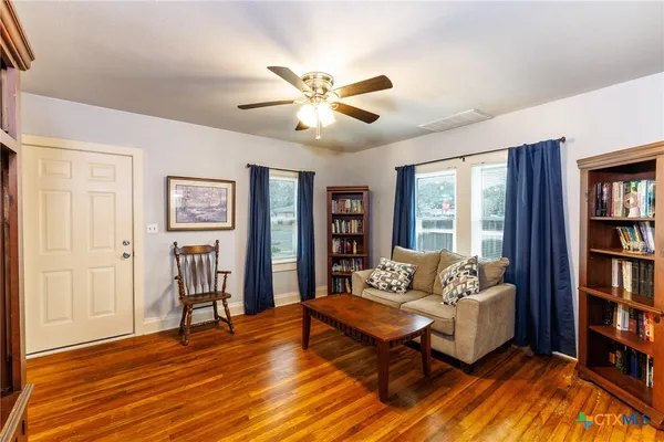 a living room with furniture and a book shelf
