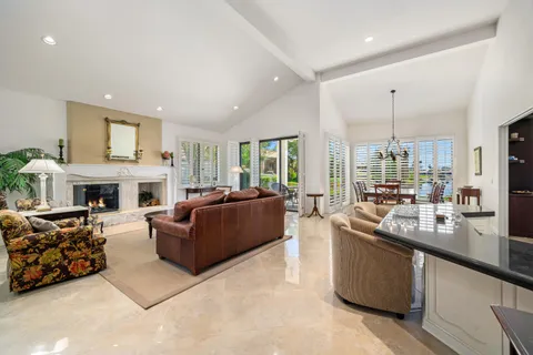 a living room with furniture a fireplace and a large window