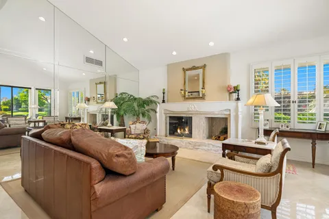 a living room with furniture fireplace and a large window