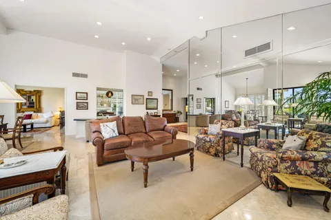 a living room with lots of furniture and a large mirror