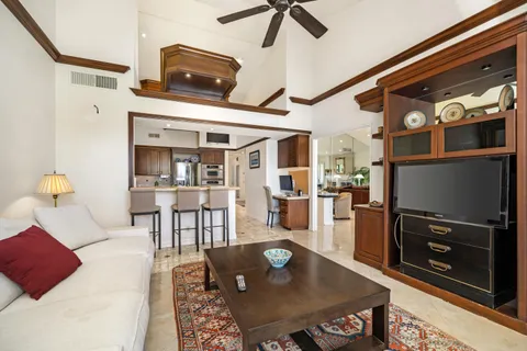 a living room with stainless steel appliances furniture a rug and a dining table