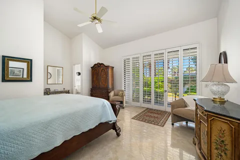 a bedroom with a bed and large windows