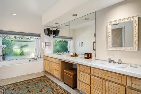 a bathroom with double vanity sink and mirror