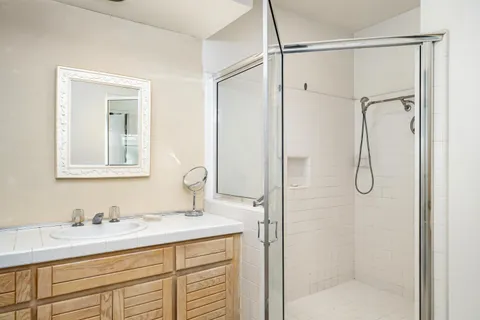 a bathroom with a granite countertop sink mirror and shower