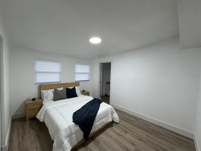 a bedroom with a bed and wooden floor