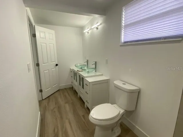 a bathroom with a sink toilet and window