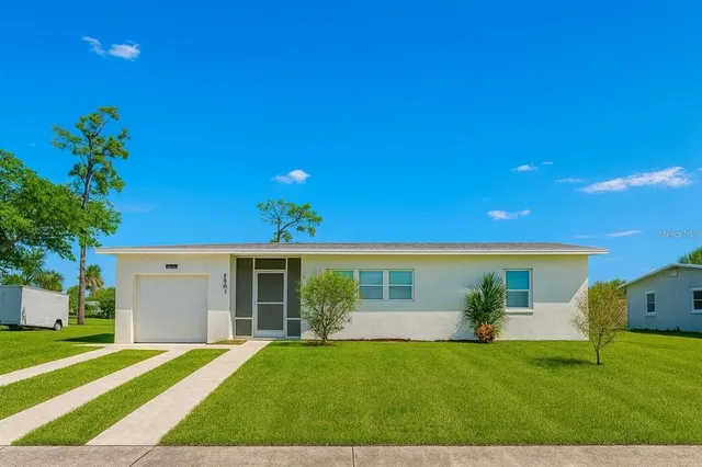 a view of a house with a yard and a garage