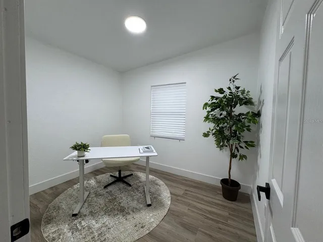 a work room with furniture and a potted plant