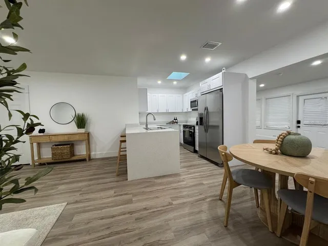 a kitchen with a table chairs stove and refrigerator