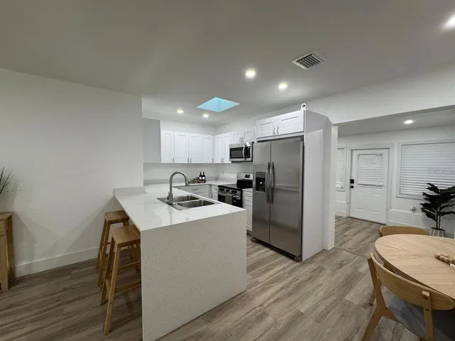 a kitchen with kitchen island a sink stove and refrigerator