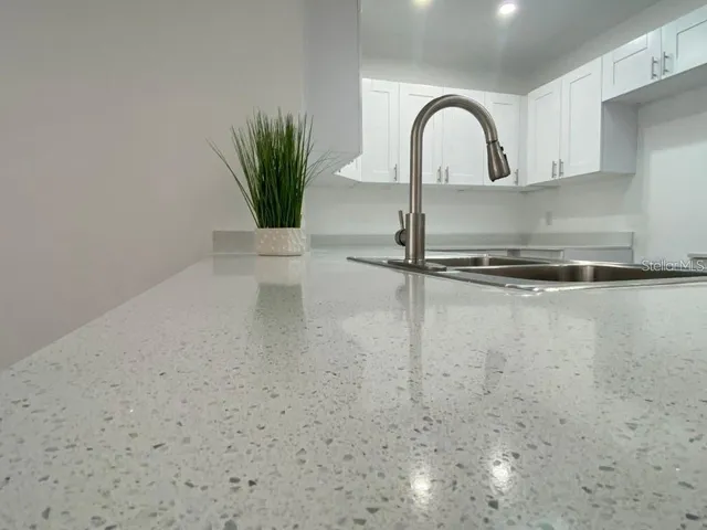 a close view of a faucet a sink and a stove in a kitchen