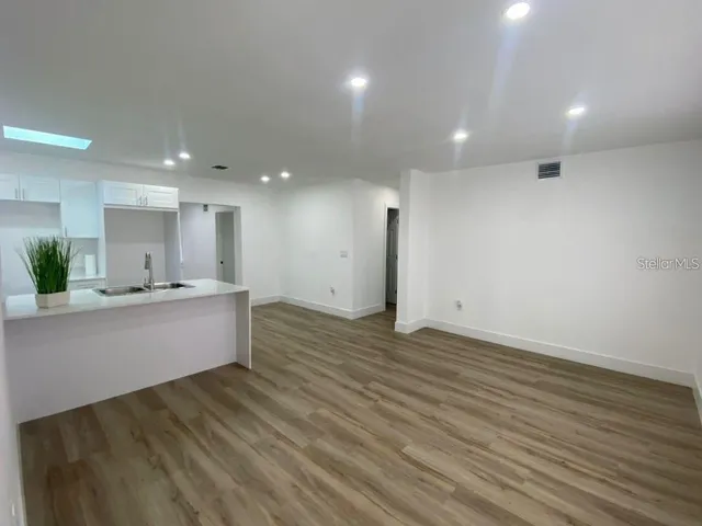 a large kitchen with stainless steel appliances a large counter top a sink and a refrigerator