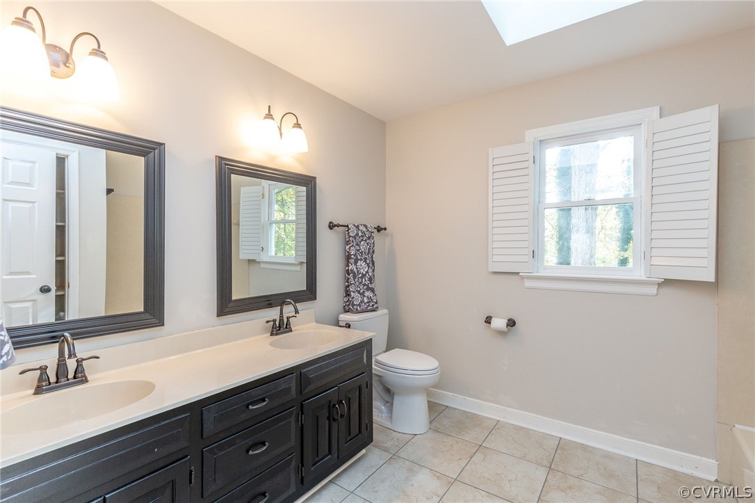 14301 Huntgate Woods Road Midlothian, VA 23112 - Photo 19 of 34 a bathroom with a double vanity sink a toilet and a mirror