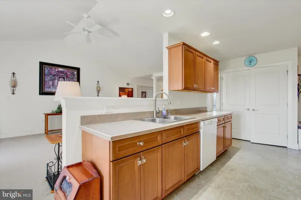 a kitchen with stainless steel appliances granite countertop a stove a sink dishwasher and a refrigerator with wooden floor