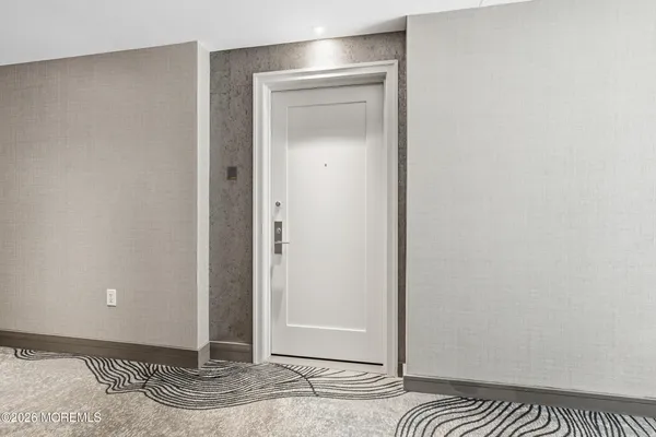 a view of a room with a door and wooden floor