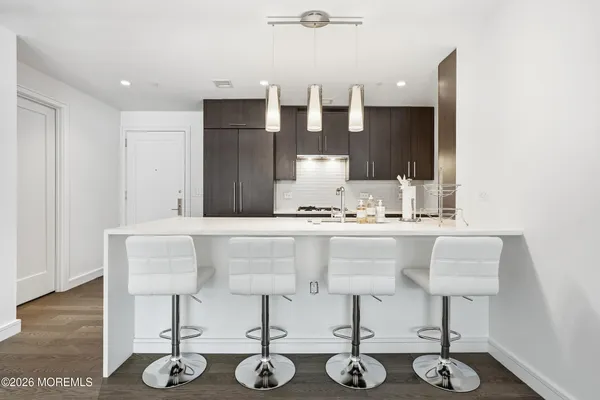 a kitchen with a sink and chairs