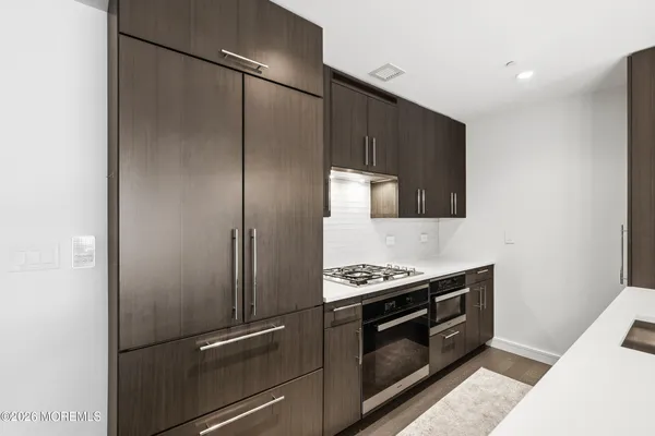 a kitchen with stainless steel appliances granite countertop a refrigerator and a stove