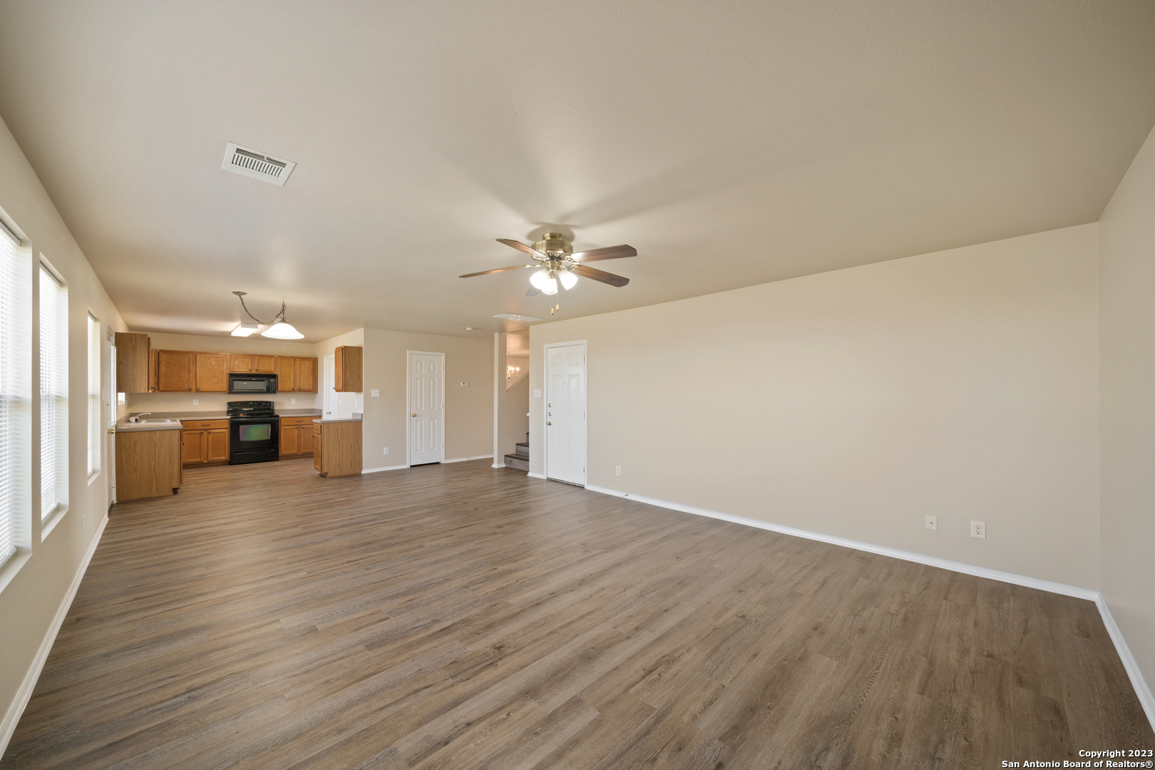 144 Crest Bluff Cibolo, TX 78108 - Photo 8 of 30 a view of a livingroom with a ceiling fan hardwood floor and kitchen view