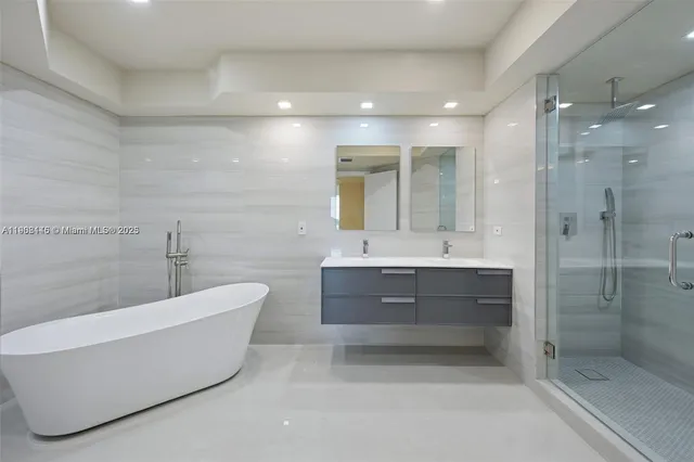 a bathroom with a bathtub shower sink mirror and toilet