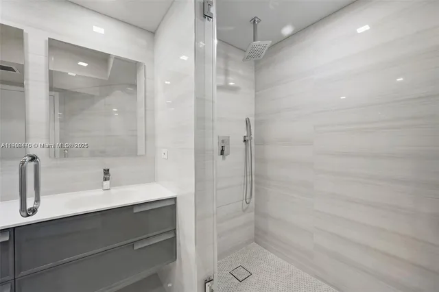 a bathroom with a shower sink vanity and mirror