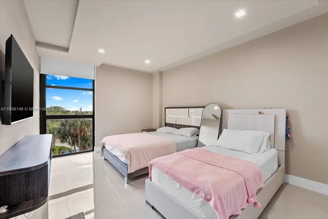 a bedroom with two beds and a flat screen tv