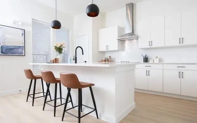a kitchen with cabinets and chairs