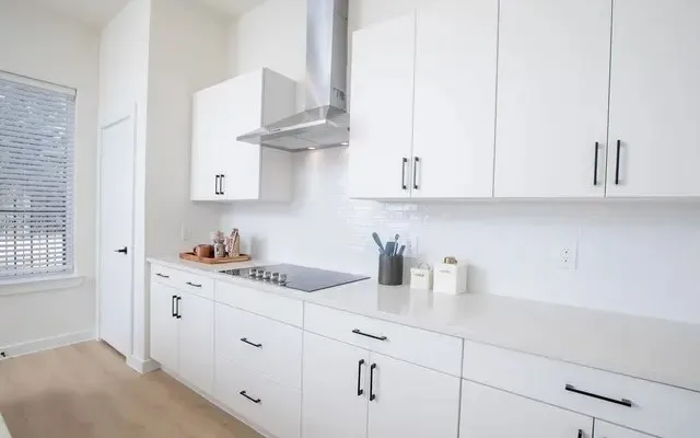 a kitchen with stainless steel appliances granite countertop white cabinets and a sink