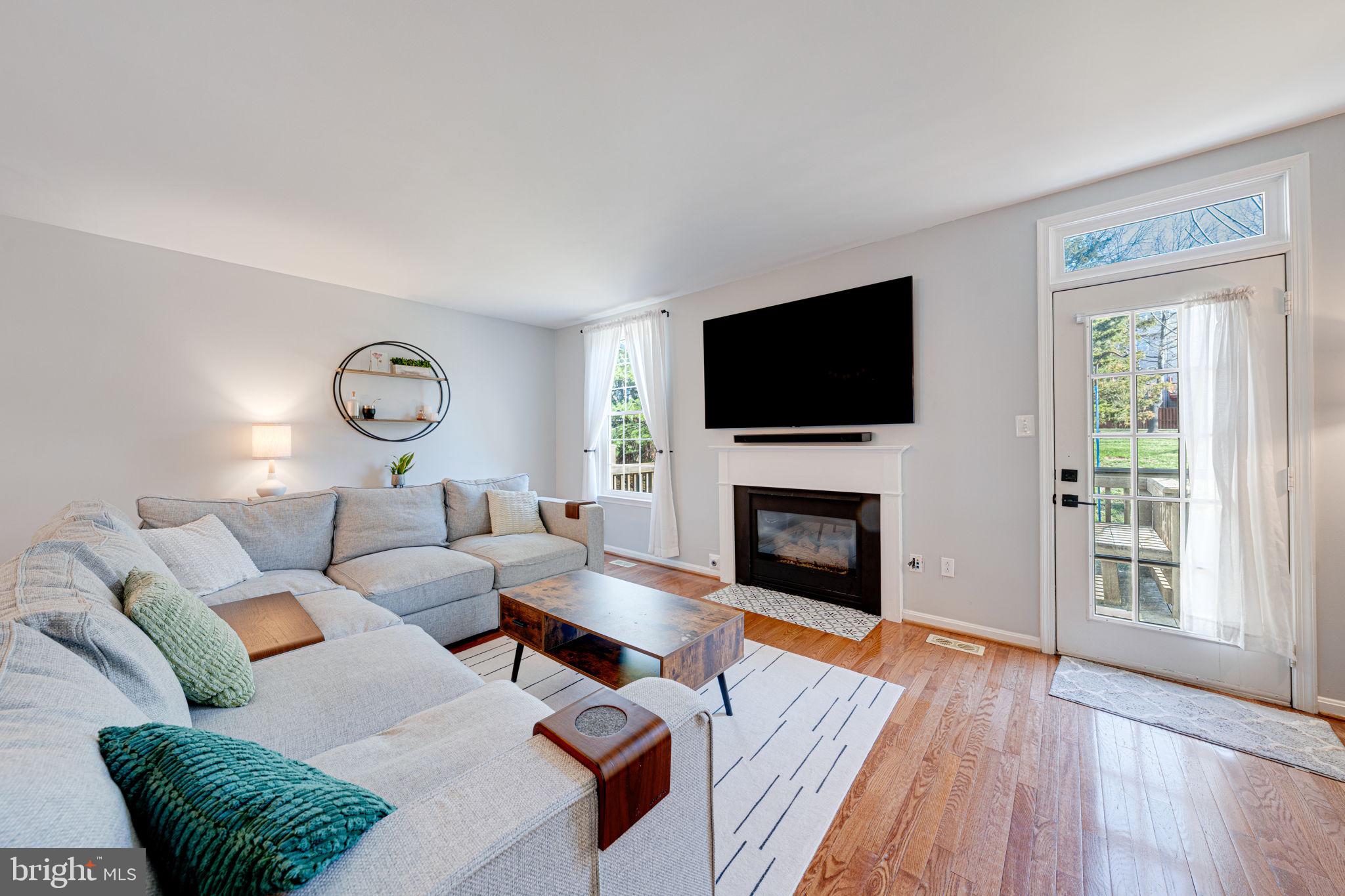 6911 Kerrywood Circle Centreville, VA 20121 - Photo 12 of 44 a living room with furniture a fireplace and a flat screen tv