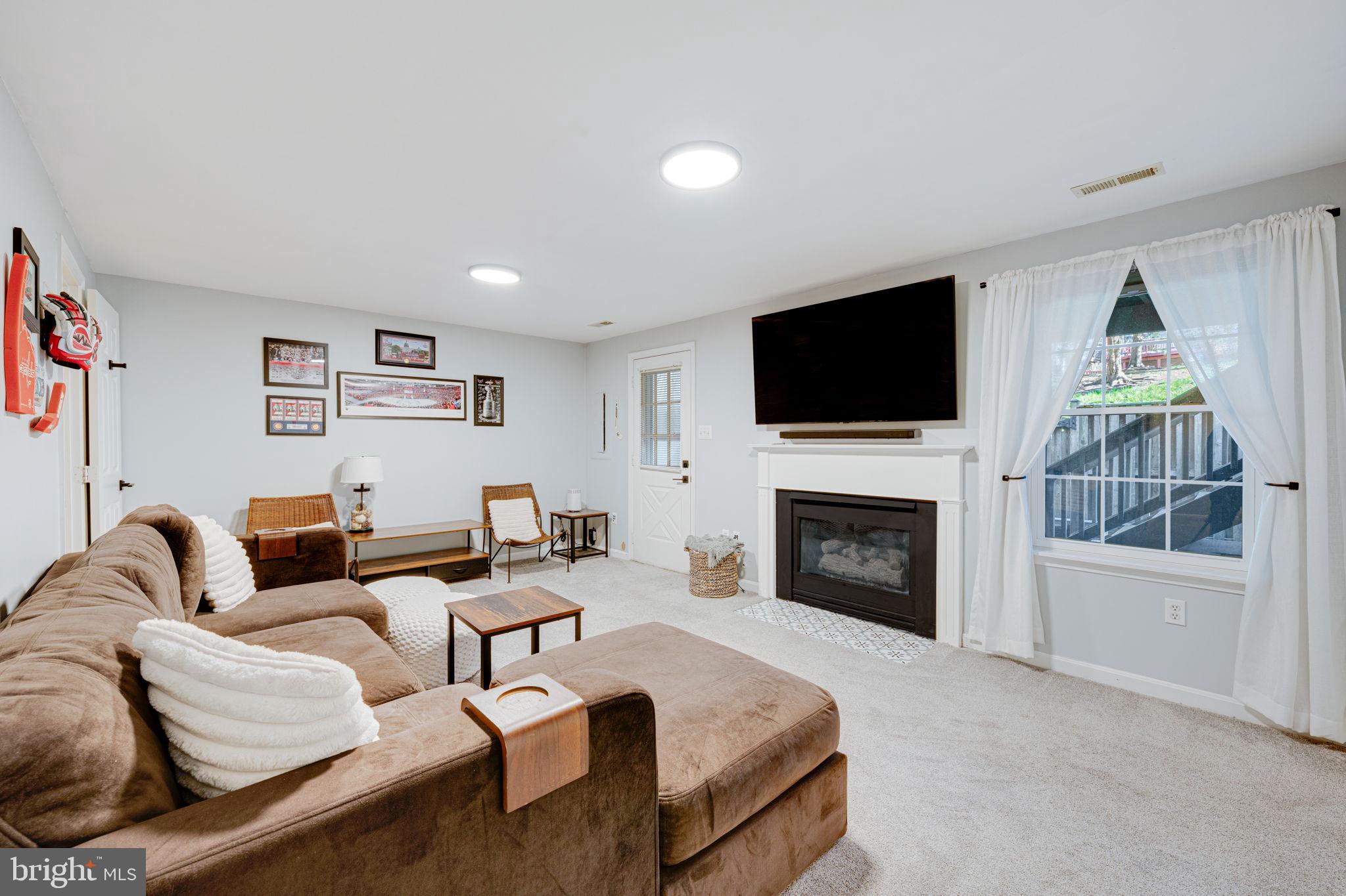 6911 Kerrywood Circle Centreville, VA 20121 - Photo 31 of 44 a living room with furniture a fireplace and a flat screen tv