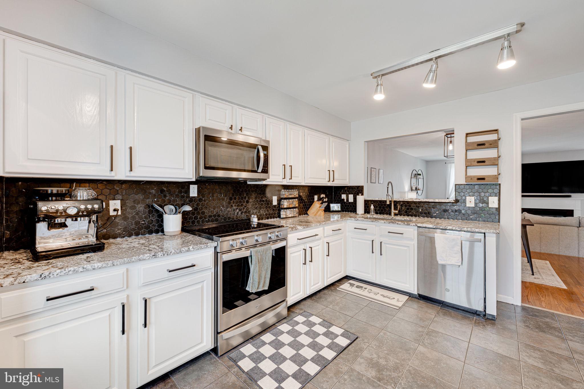 6911 Kerrywood Circle Centreville, VA 20121 - Photo 9 of 44 a kitchen with stainless steel appliances granite countertop a stove top oven a sink a microwave and cabinets