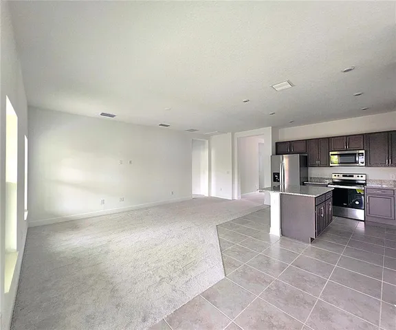 a view of kitchen with kitchen island and stainless steel appliances