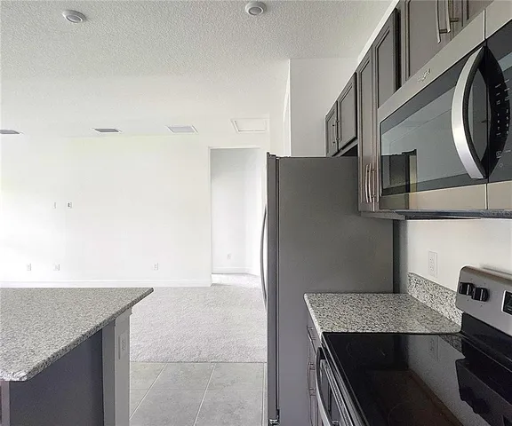 a kitchen with stainless steel appliances granite countertop a refrigerator and a stove