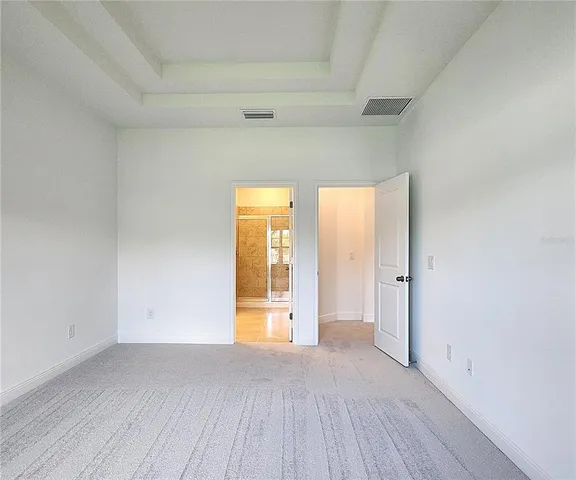 a view of an empty room with wooden floor and windows