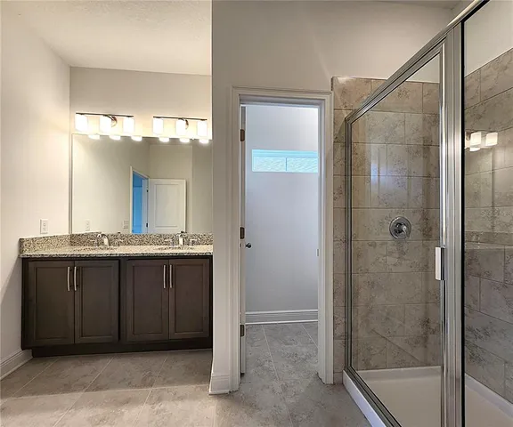 a bathroom with a granite countertop sink mirror and shower