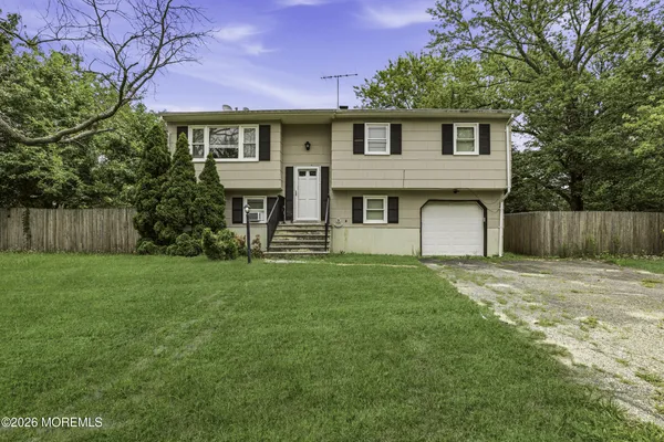 a front view of a house with a yard and trees