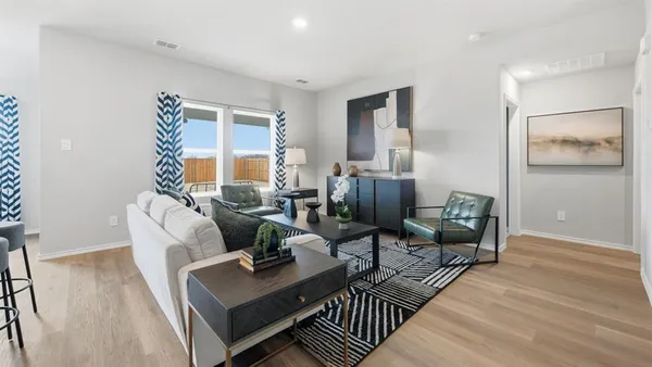 a living room with furniture and a view of kitchen