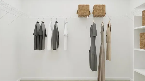 a view of walk in closet with clothes