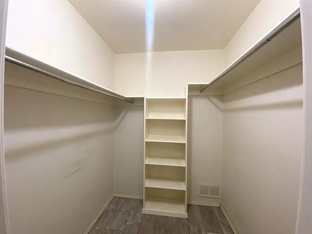 a view of walk in closet with empty racks